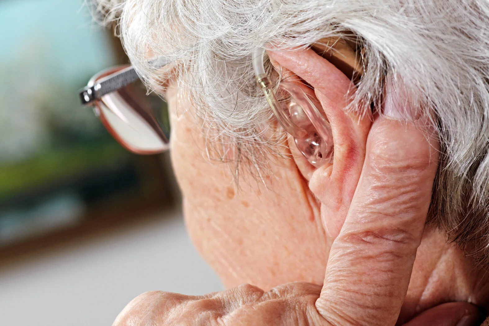 Hörgerät über dem Ohr einer Seniorin