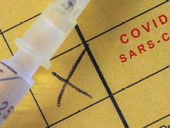Impfpass mit Covid-Impfeintrag, Spritze