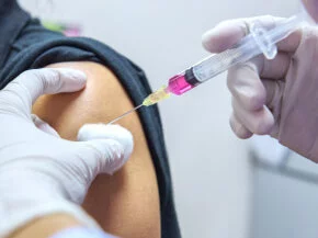 Impfung, Spritze mit Impfstoff wird injiziert