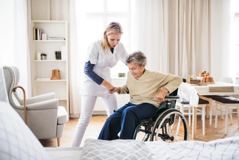 Bewegung, Positionierung: Pflegerin hilft Seniorin aus dem Rollstuhl